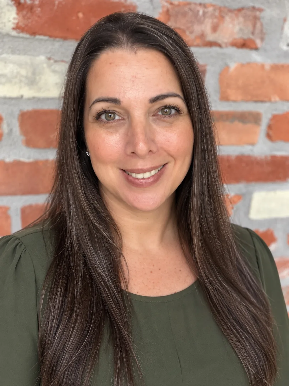 Melissa Shaw, LCSW-BACS, smiling in front of a brick wall